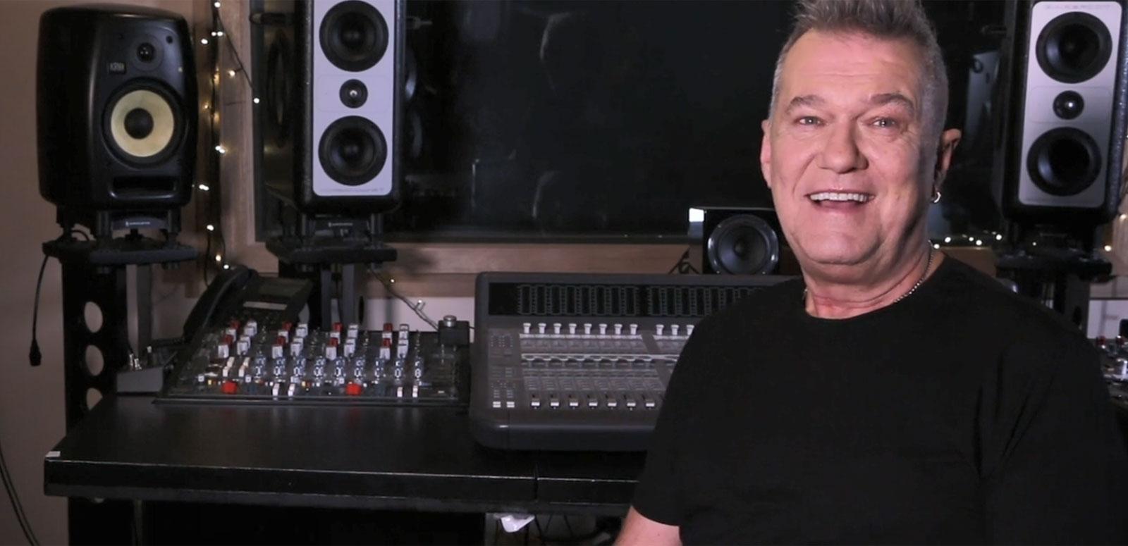 Singer Jimmy Barnes pictured from the chest up, in a black t-shirt and sitting in front of a mixing deck in a recording studio.