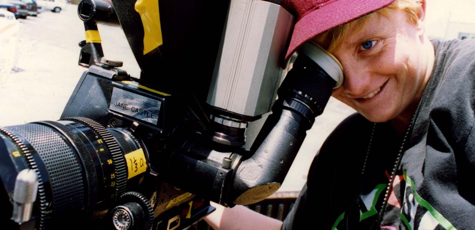 Cinematographer Jane Castle looking through the viewfinder of a film camera