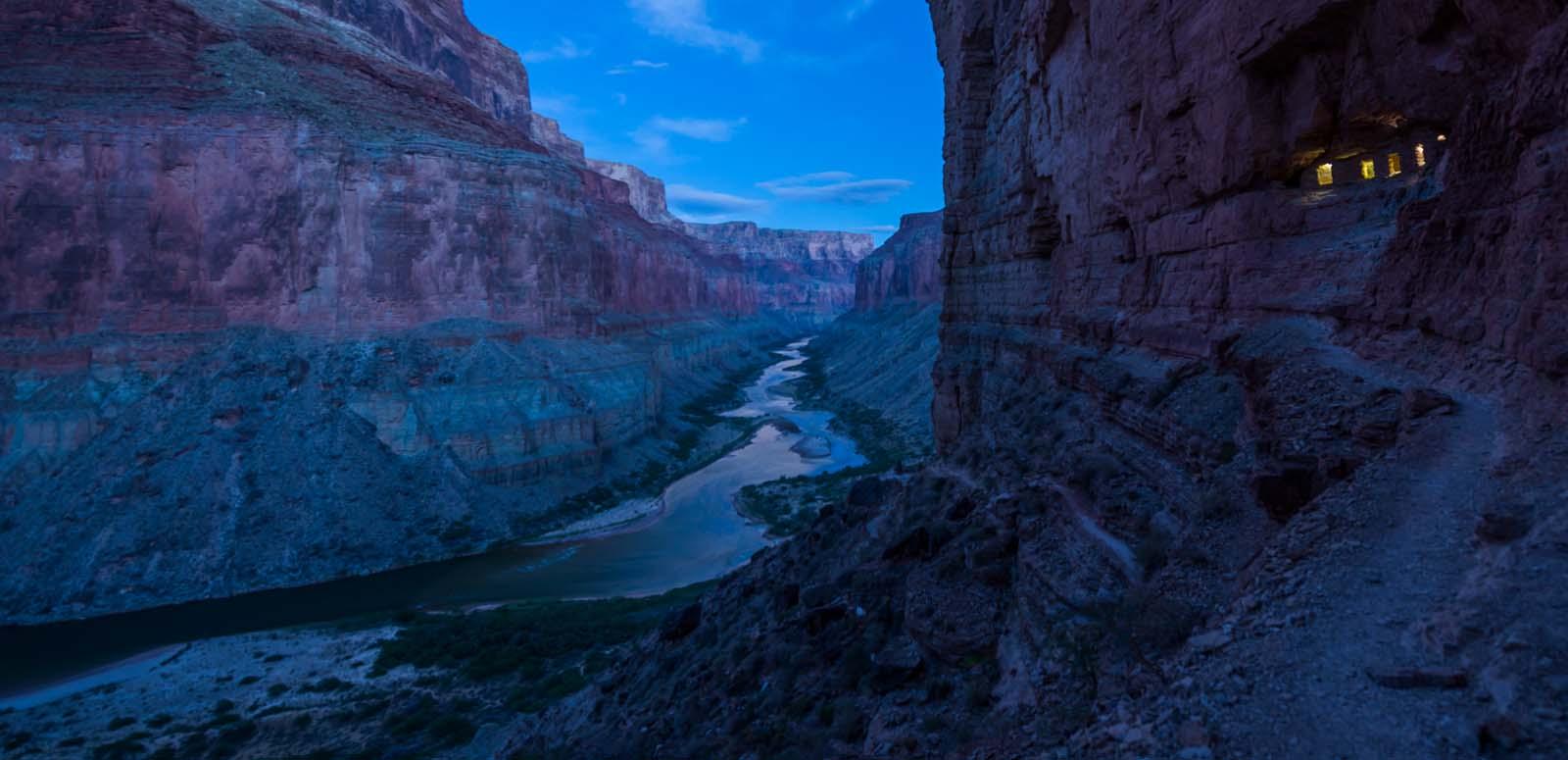A river passing through a spectacular Grand Canyon landscape during the dark blue of night