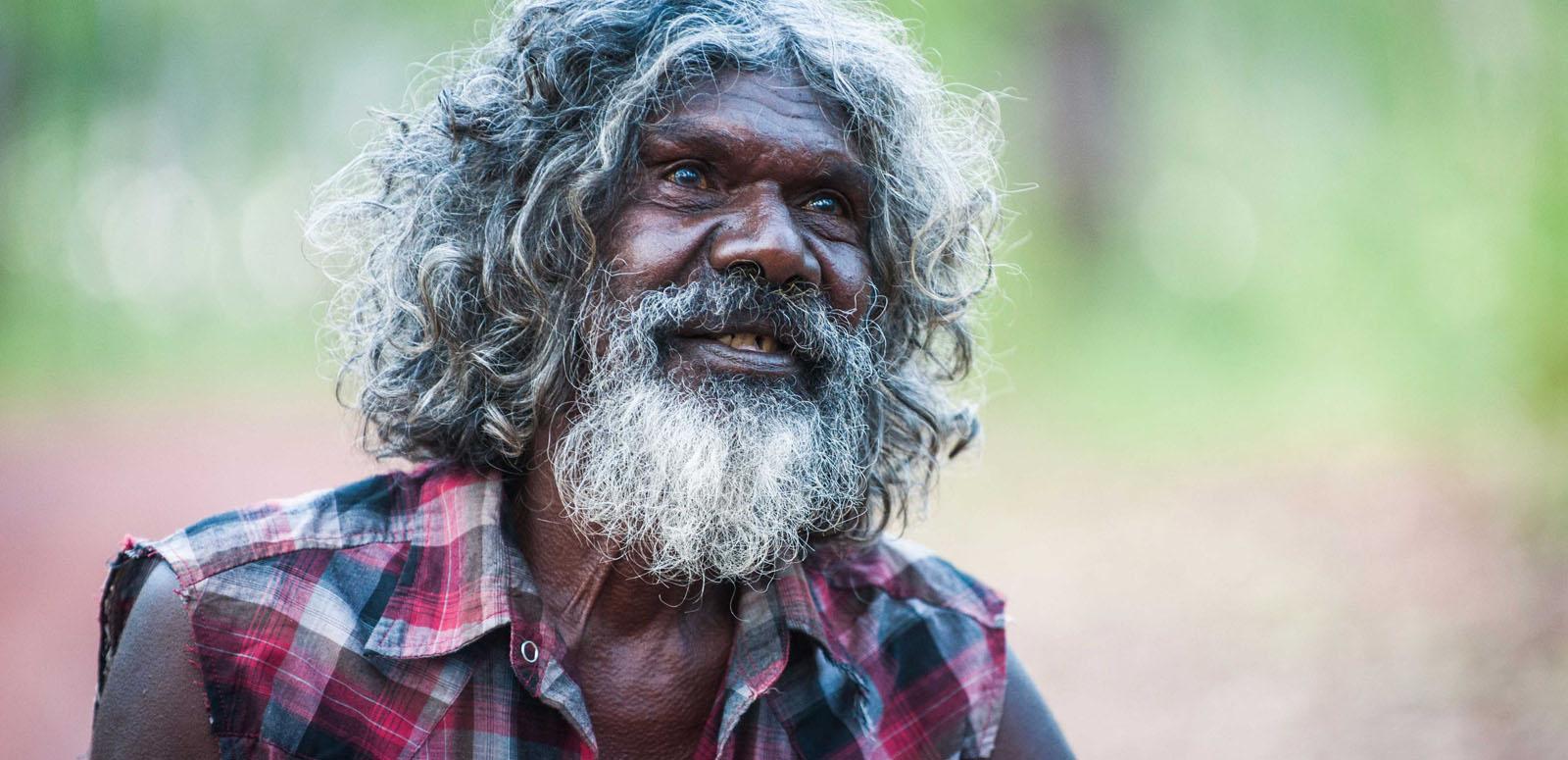 David Gulpilil in a production still from Charlie's Country. He is looking up and smiling. His hair and beard is going grey. 