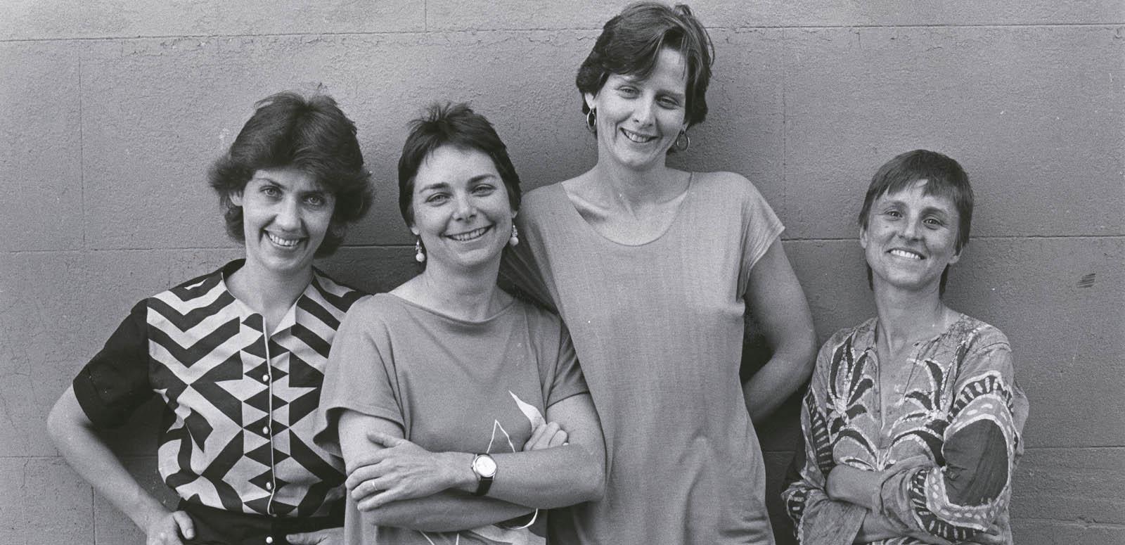 Filmmakers Margot Nash, Megan Mcmurchy, Jeni Thornley and Margot Oliver standing in front of a wall smiling for the camera.
