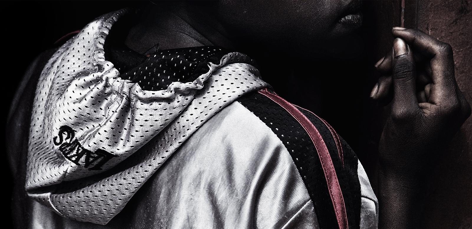A young Aboriginal man wearing an athletics hoodie and looking away from the camera