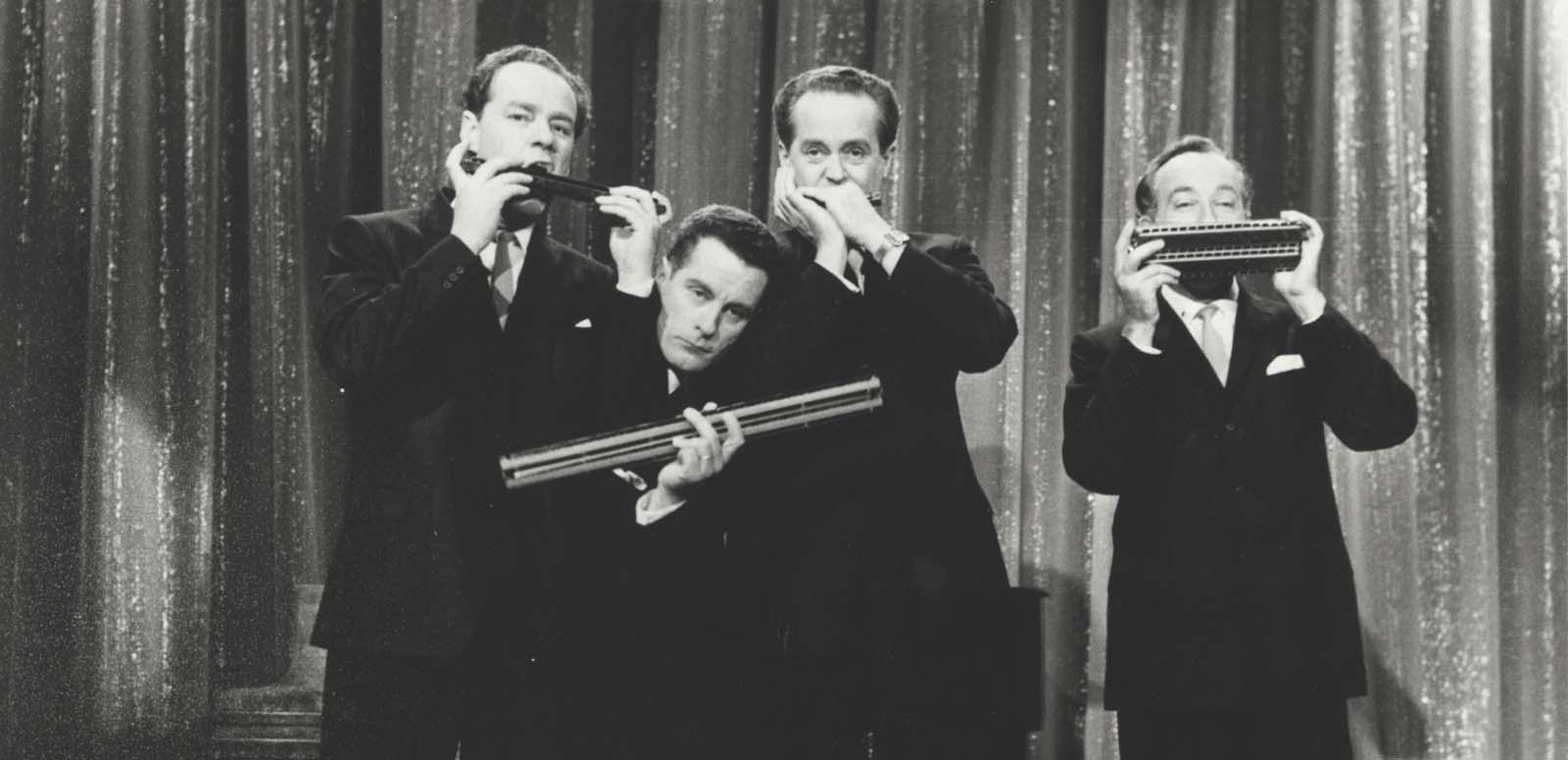 Horrie Dargie Quintet The members of the Horrie Dargie Quintet pose in front of a curtain, each member holding a harmonica