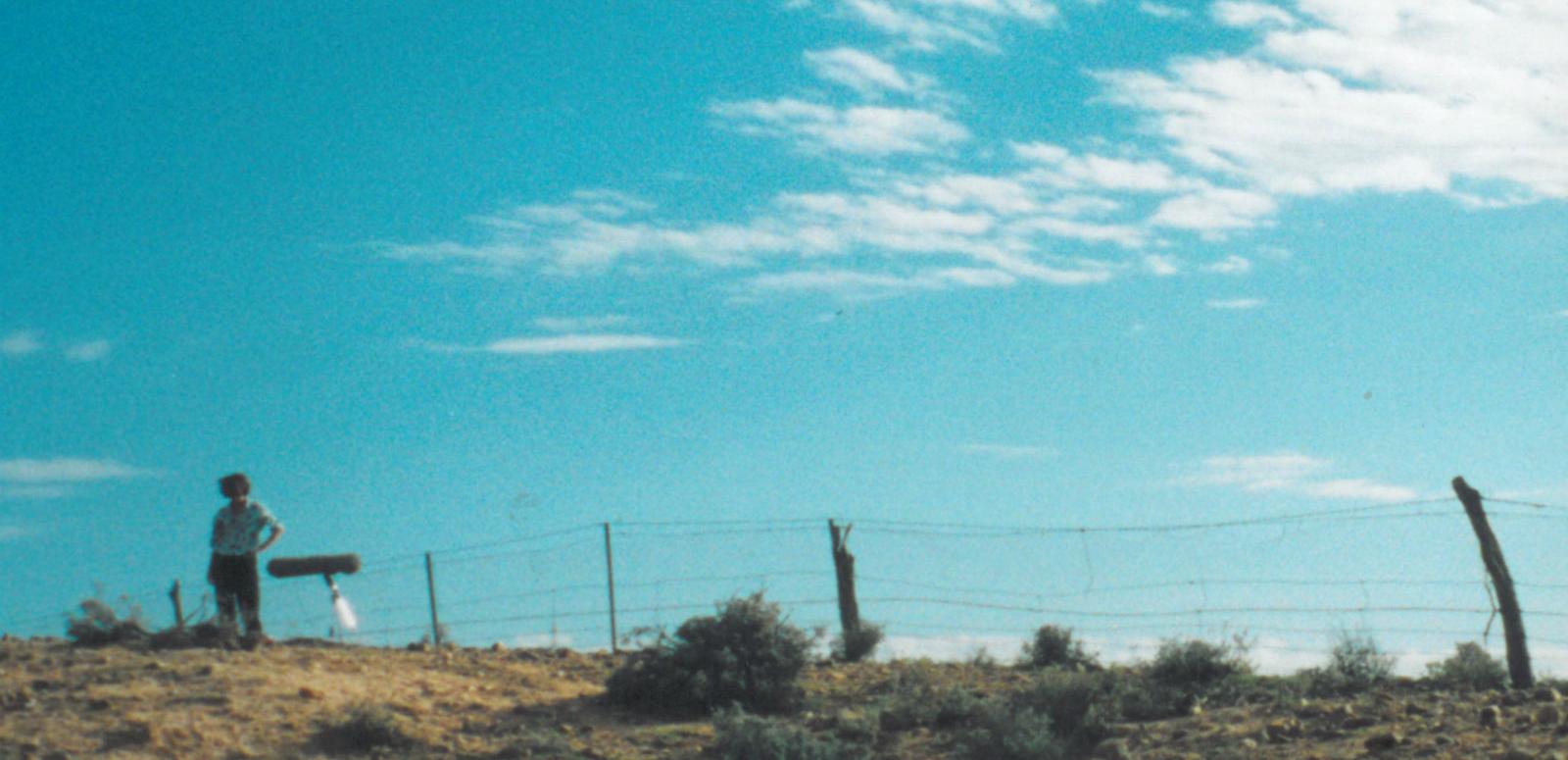 Bronwyn Murphy blog hero image Bronwyn Murphy photographed near fence from a distance with blue sky in the background during filming of Rabbit Proof Fence