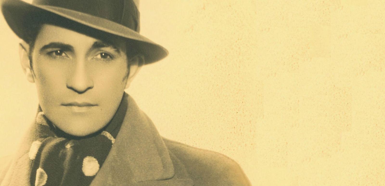 Portrait of Con Colleano in hat and coat looking away from camera