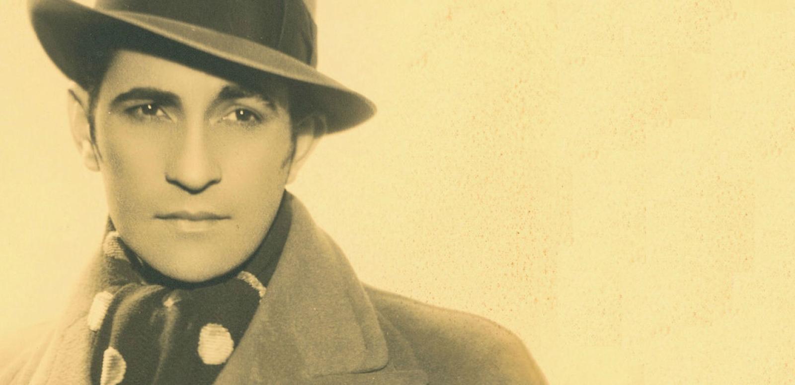 Portrait of Con Colleano in hat and coat looking away from camera