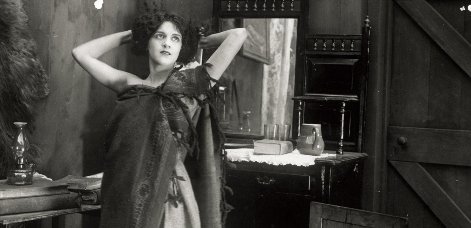 Still image from Moth of Moonbi showing Doris Ashwin standing with hands behind her head