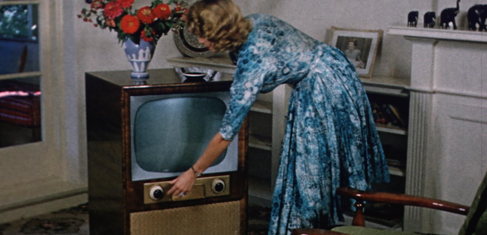 TV turns 60 blog hero image 1950s image of a woman turning on a television set in her living room.