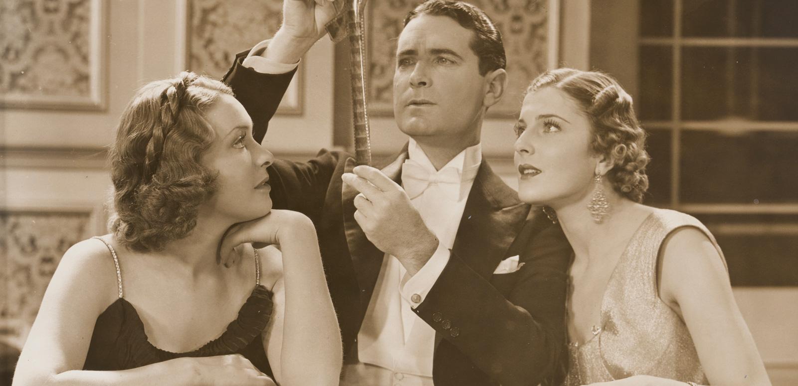 Lovers and Luggers Publicity still of Shirley Ann Richards as Lorna Quidley, Lloyd Hughes as Daubenny Carshott and Elaine Hamill as Stella Raff examining a film strip.