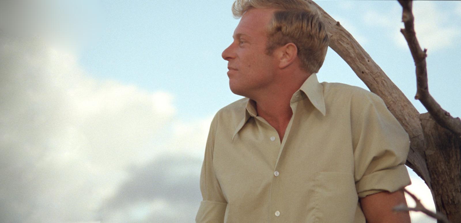 Image of actor Jack Thompson pictured from the chest up, looking sideways, in a still image from the film Sunday Too Far Away.