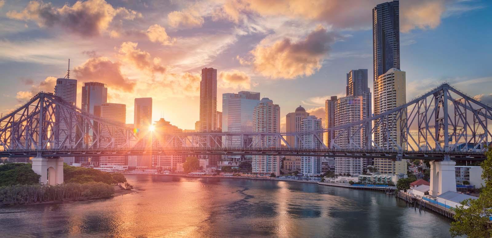 Brisbane in early morning with the sun shining on city buildings and the Brisbane River
