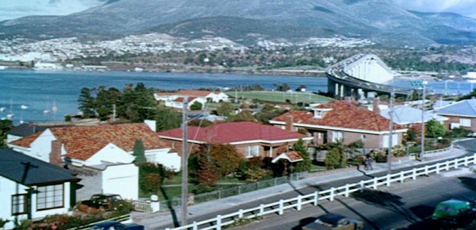 Viewpoint on Hobart A colourful vista of Hobart showing roof tops and the Tasman Bridge and Mount Wellington in the background.