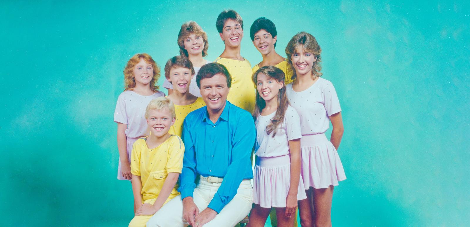 Eight children from the Young Talent Time team are pictured with Johnny Young in the centre. It is a studio shoot. Featured: Vanessa Windsor, Beven Addinsall, Greg Poynton, Vince Del Tito, Dannii Minogue, Karen Dunkerton, Katie Van Ree, Joey Perrone