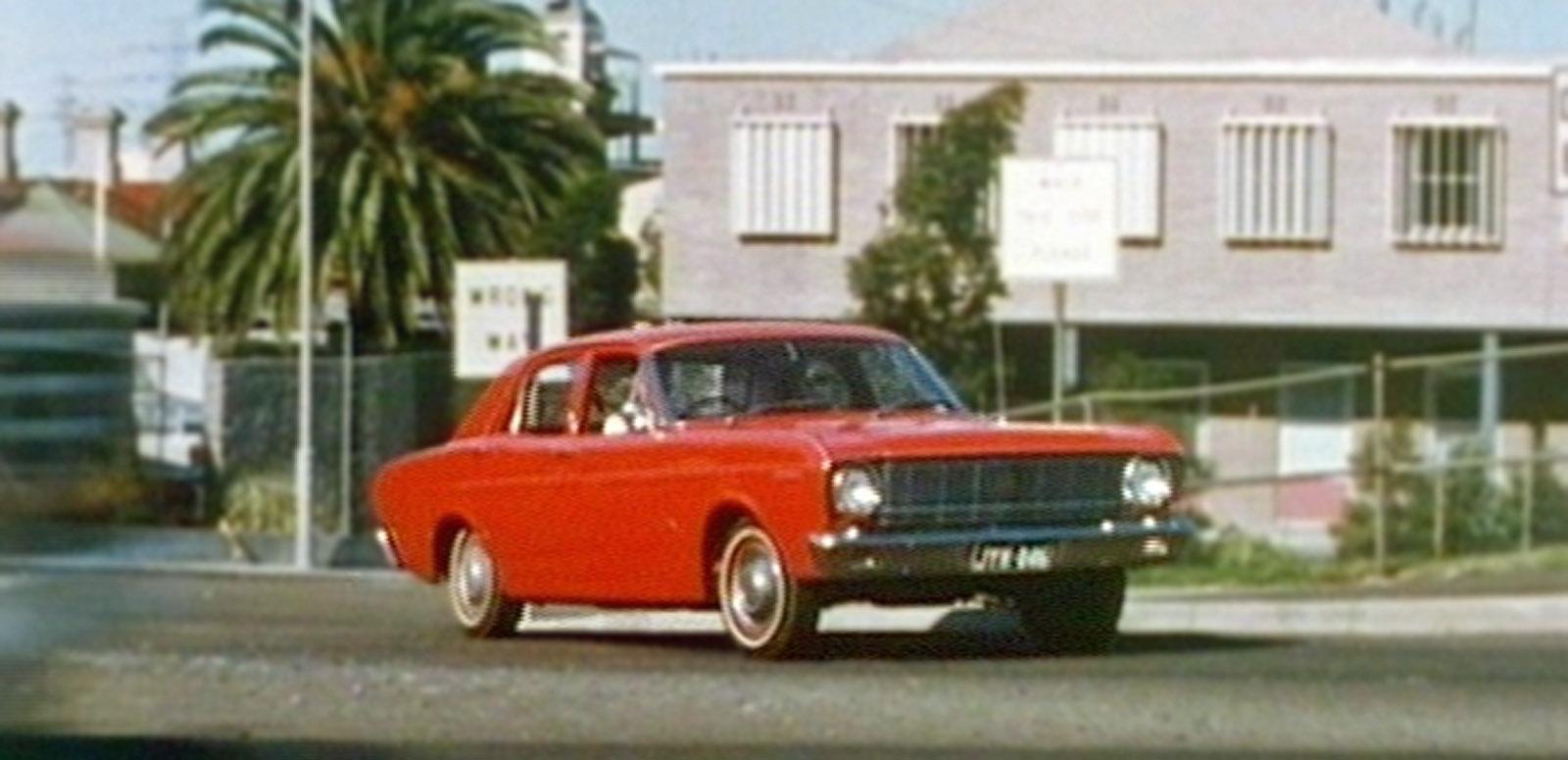 How to Drive A red 1968 Ford XT Falcon drives along a suburban street.