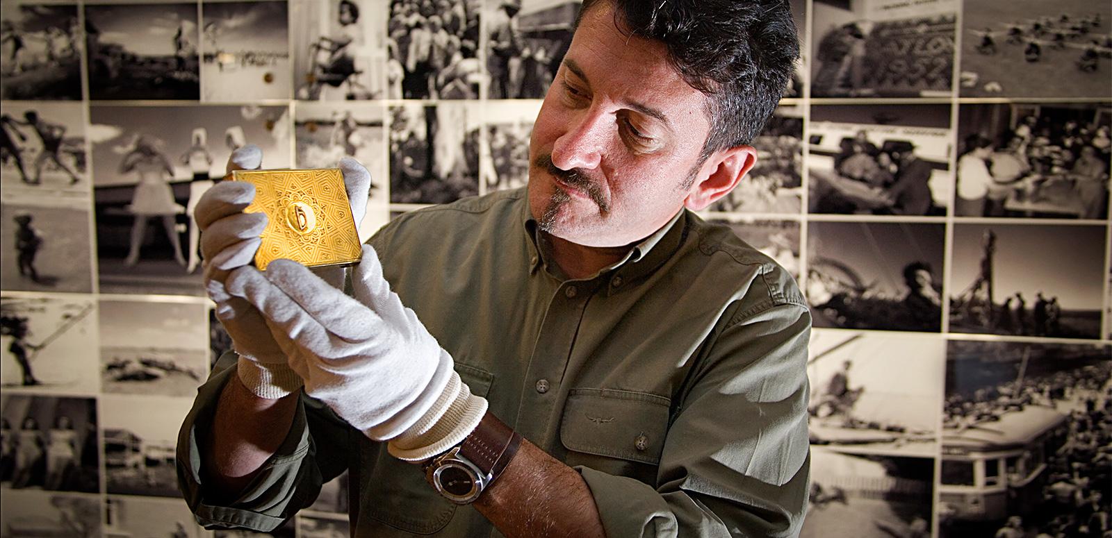 Warren Brown holds up a gold cigarette case at the National Archives of Australia Warren Brown holds up a gold cigarette case at the National Archives of Australia