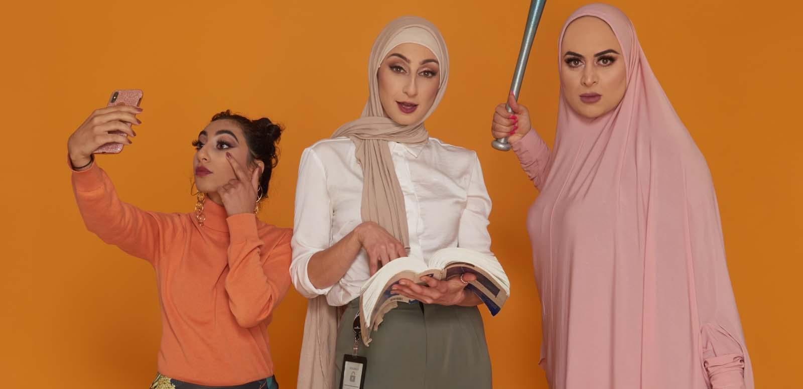 Three young women - two wearing the hijab - stand next to each other. One is taking a mobile phone selfie, another in corporate dress holds a law book, while the third wields a baseball bat.