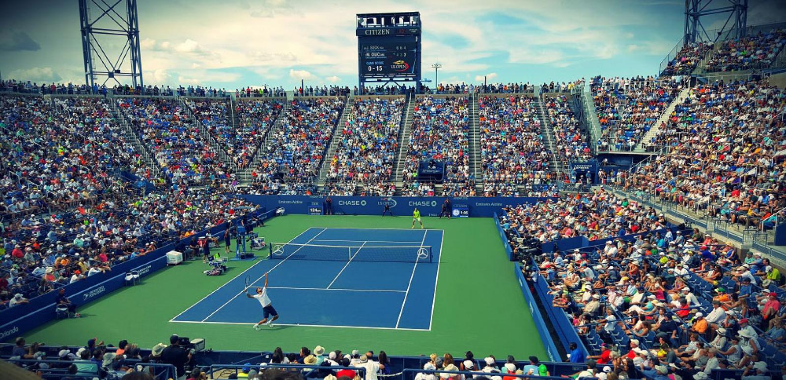 Elevated photo of tennis stadium with large crowd watching a match. Elevated photo of tennis stadium with large crowd watching a match.