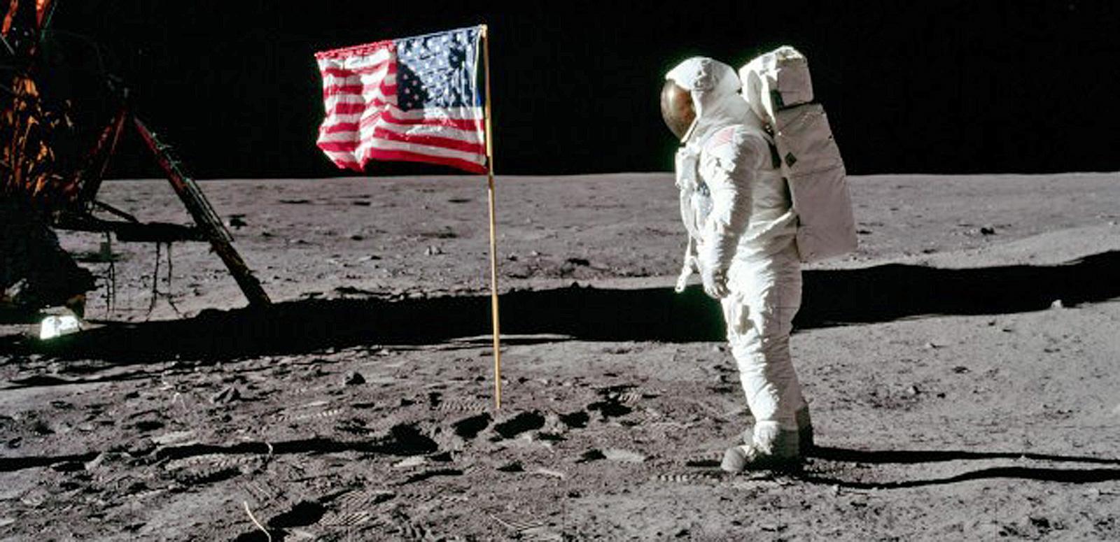 Astronaut on the moon standing near the American flag Astronaut on the moon standing near the American flag