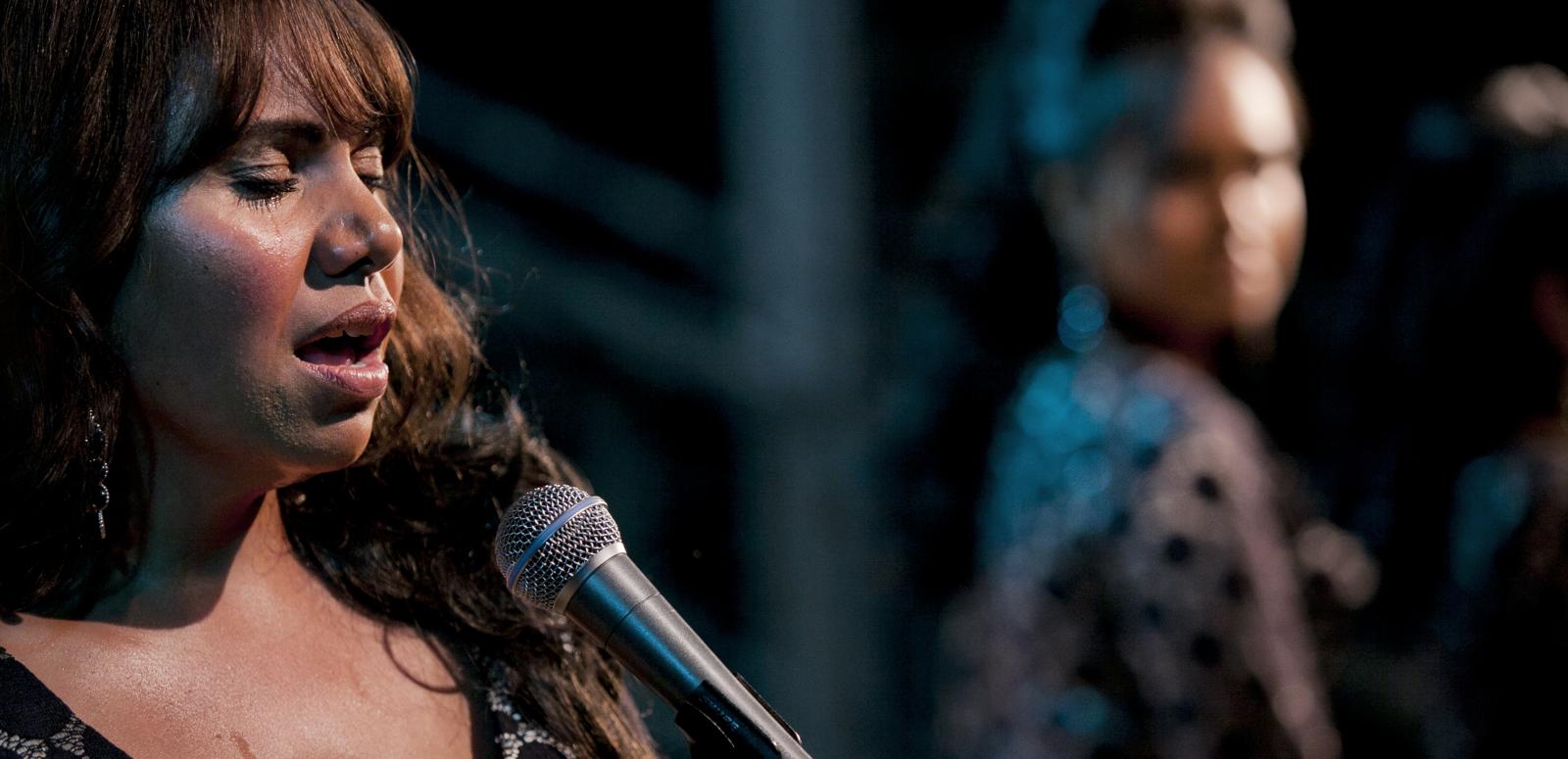Deborah Mailman singing on stage in a still from the film The Sapphires