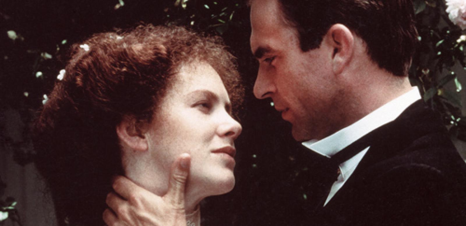 Judy Davis as Sybylla and Sam Neill as Harry embrace. He is touching her neck and she is touching his arm. They look at each other lovingly.
