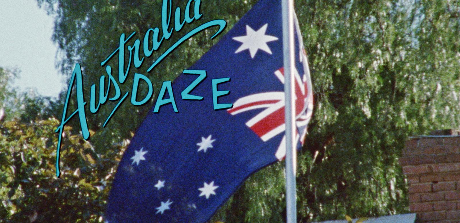 An Australian flag flying on a flag pole with the film title 'Australia Daze' superimposed over the top.
