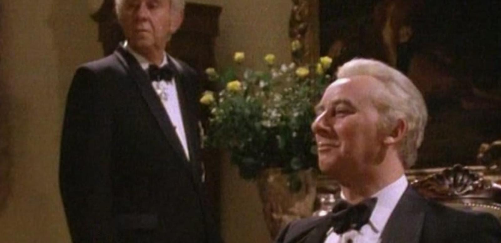 Sir John Kerr (John Meillon) standing and Prime Minister Gough Whitlam (Max Phipps) seated in formal attire
