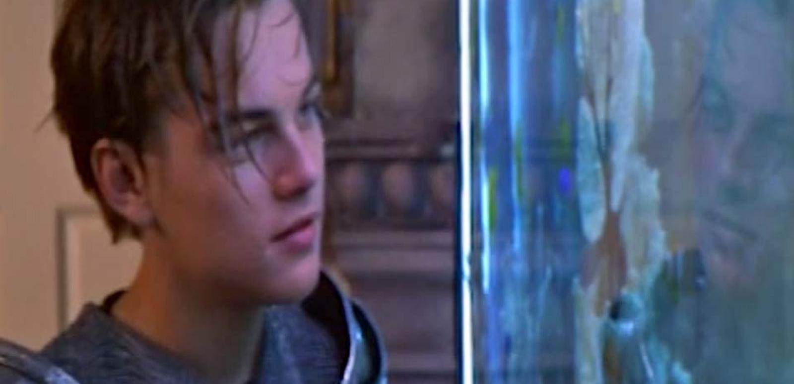 Leonardo DiCaprio as Romeo looks at Juliet through the glass of an aquarium.