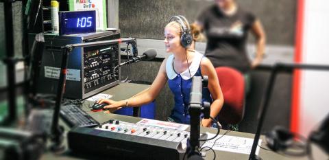 Two young women at a radio mixing desk at SYN Media