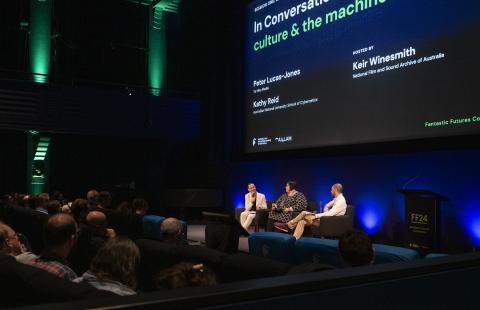 Peter-Lucas Jones, Kathy Reid and Keir Winesmith presenting a panel on a stage