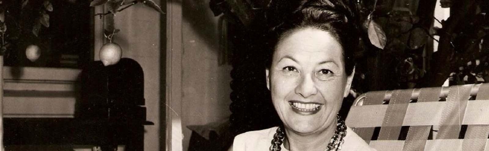 Radio and TV interviewer Binny Lum sits smiling in her home