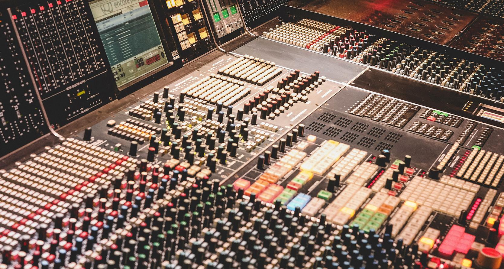 A recording studio mixing board covered in switches and buttons
