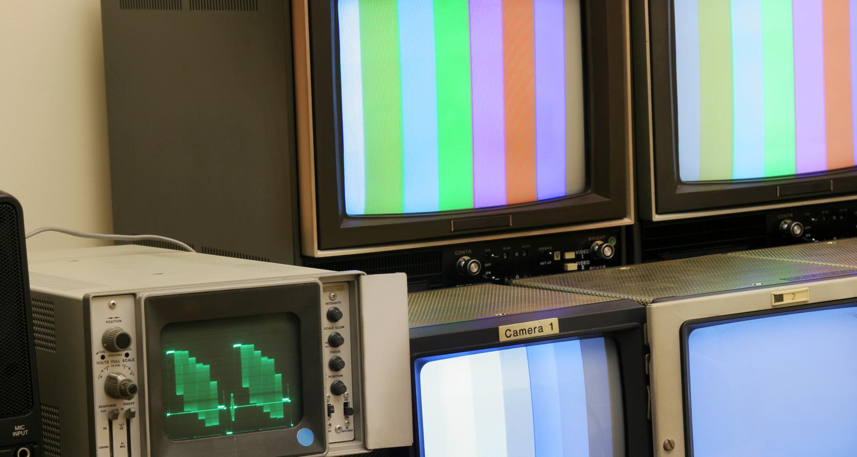 A retro television set against a floral wall