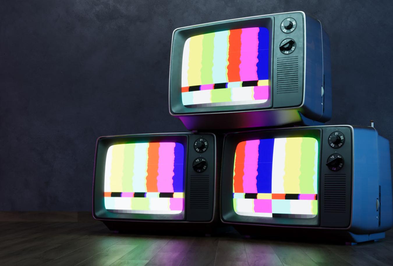 Three television sets stacked on top of each other displaying a coloured test pattern.