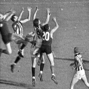Australian Rules Football players jumping for the ball in the 1964 grand final match.