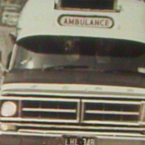 A 1970s ambulance driving to an accident scene.