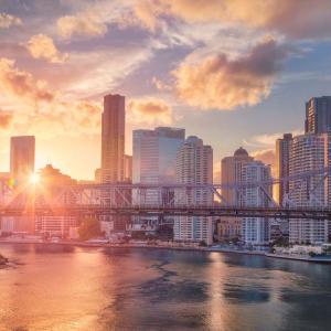 Brisbane in early morning with the sun shining on city buildings and the Brisbane River