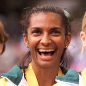 Nova Peris flanked by team mates receiving an Olympic gold medal