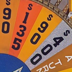A section of a game show wheel with different dollar amounts written on each section and one section that says Lose A Turn.