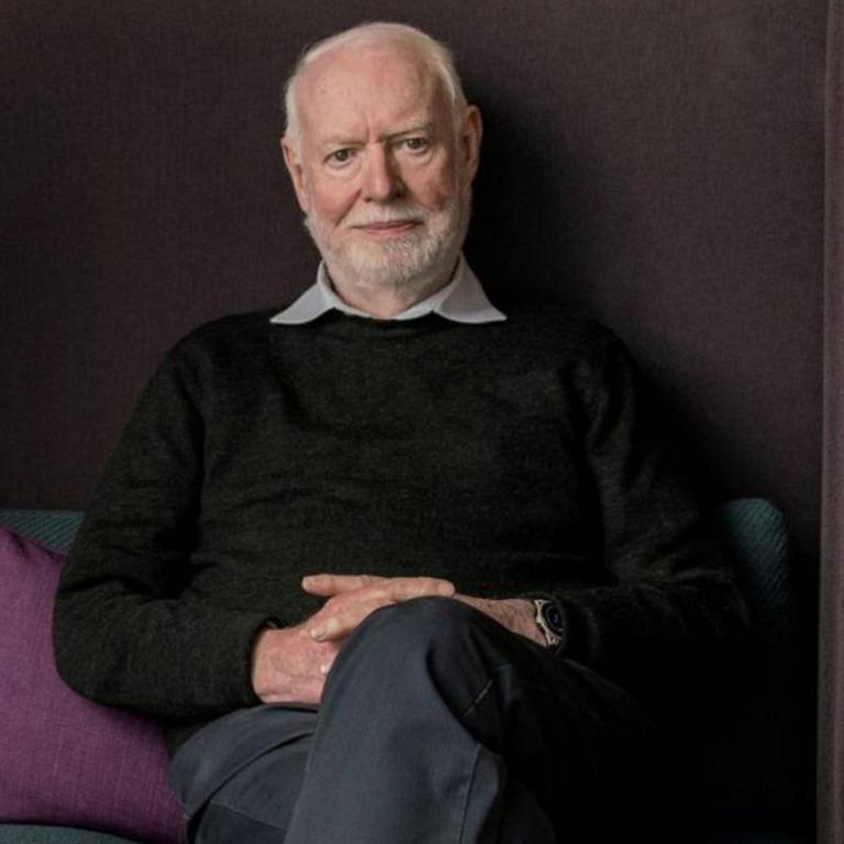 Film critic and author David Stratton seated on a sofa looking directly at the camera.