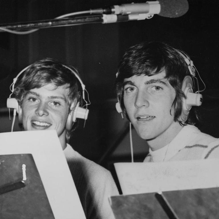John Farnham and Jeff Phillips pictured from the shoulders up in a studio wearing headphones, circa 1972