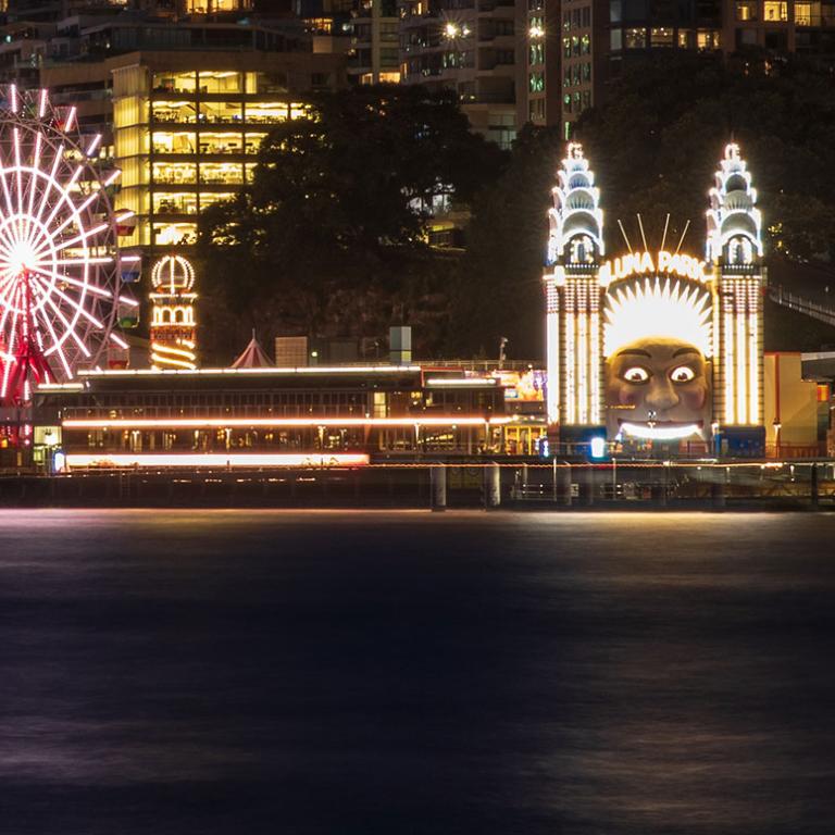 Luna Park in Sydney lit up at night, pictured from across Sydney Harbour