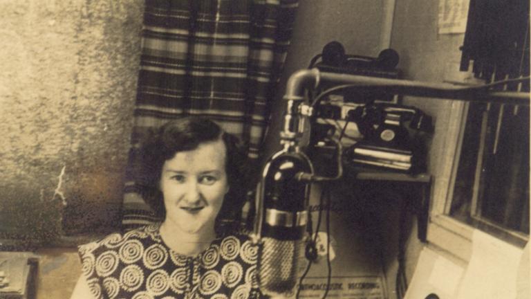 Enid Hogan behind a microphone in a radio studio