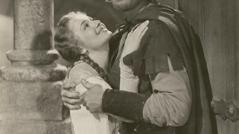 Errol Flynn and Olivia de Havilland embrace.