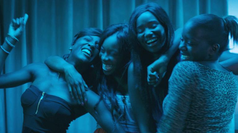 A group of young women hugging each other and laughing.
