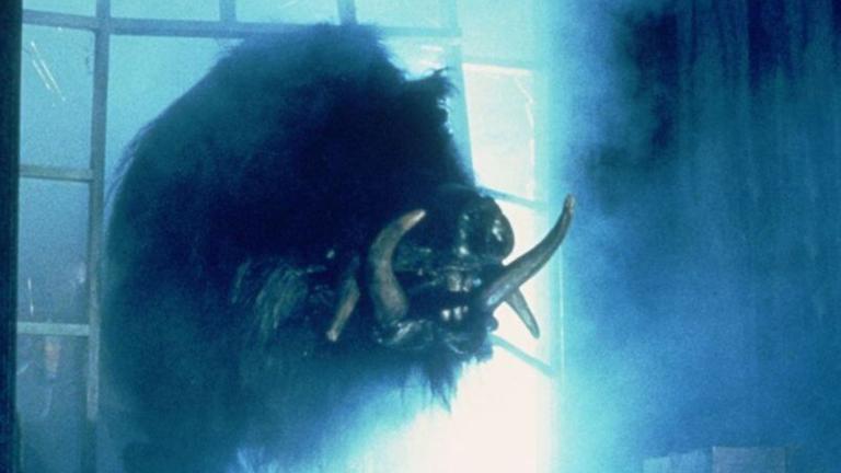 A giant boar bursts through a glass panelled window.