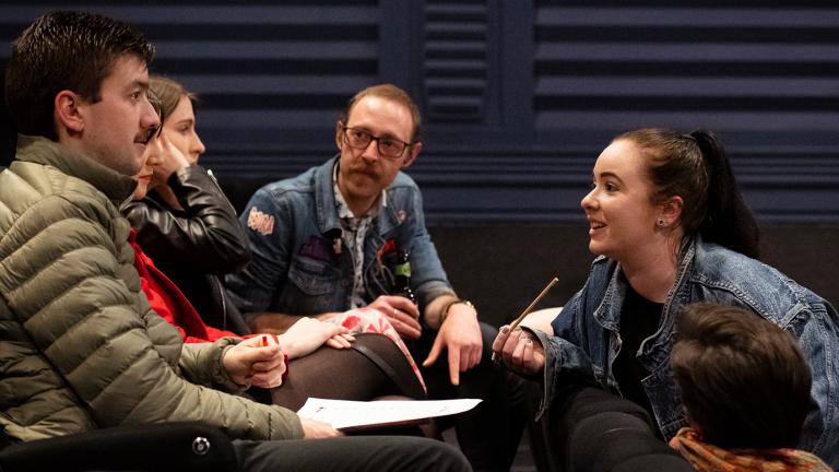 A group of four people sitting in a huddle.