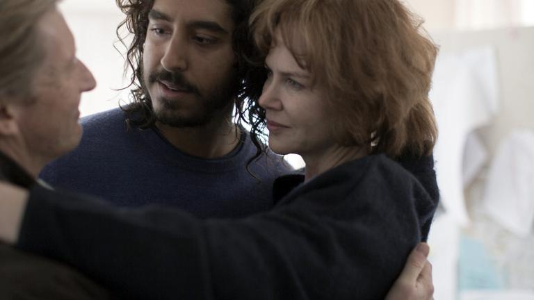 Family shot of a middle-aged man and woman embracing a young man
