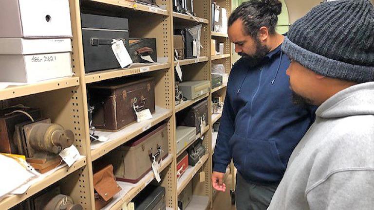 Two young First Nations men looking at items in the vaults at the NFSA.