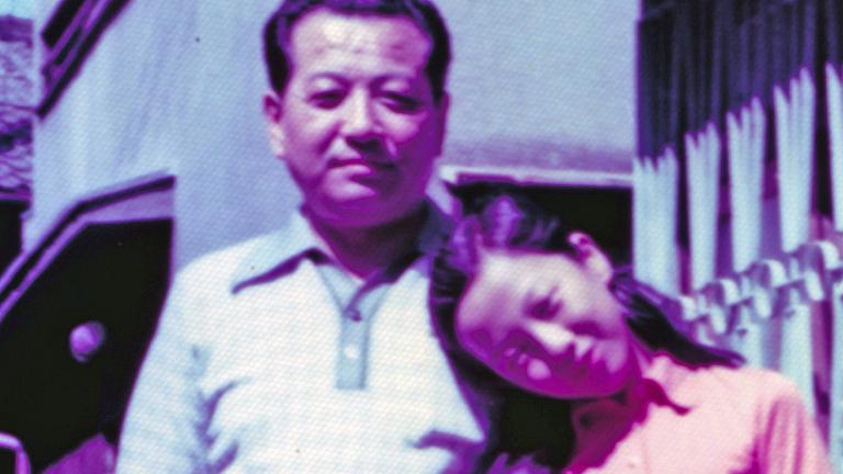 A middle-aged Korean man standing with his pre-teen daughter. They are looking directly at the camera.