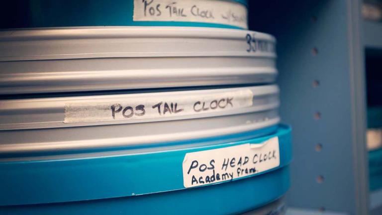 A stack of film cans on an archive shelf